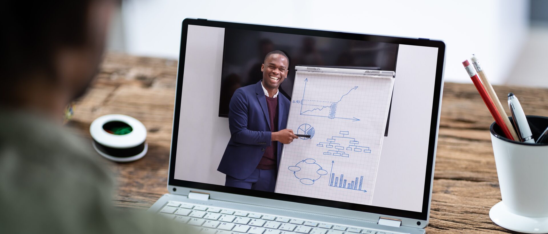 A man is holding a whiteboard and smiling